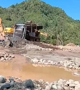 Aktifitas Penambangan Emas Ilegal (PETI) oleh PT. Putra Lebak Perkasa di sungai desa Labuton, kecamatan Gadung, Kabupaten Buol. Tampak  alat berat exavator tengah melakukan penggalian di badan sungai.