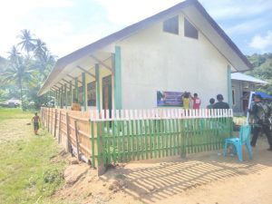 Tampak Bupati Bolmut disaat menggunting pita dalam rangka peresmian SDN 18 Bolangitang Barat tepatnya di Desa Tanjung Buaya, yang di dampingi kepala adat Desa