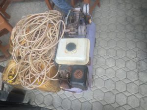 Tampak 1 Unit Kompresor, 2 Bal Selang, dan tampak beberapa galon terisi BBM Silar