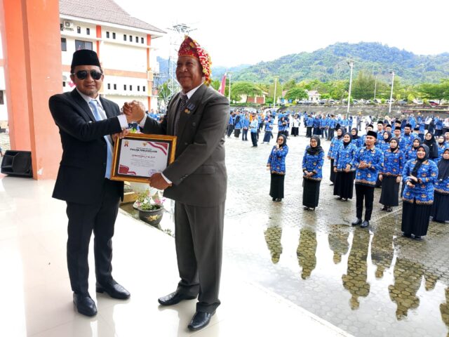 Wabup Tojo Una-una Hj. Sury saat menyerahkan bingkisan kepada Plt. Kepala Dinas Pendidikan Pemuda dan Olahraga,Burhanudin Lahay pada hari lahirnya Pancasila, Minggu 1 Juni 2025