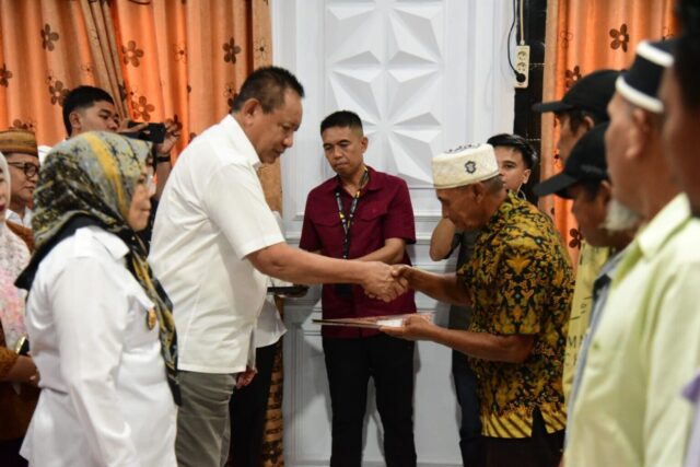 Gambar: Gubernur Gorontalo Gusnar Ismail saat menyerahkan Sertifikat Hak Milik (SHM), dalam kegiatan yang digelar di Kantor Camat Paguyaman Pantai, Kabupaten Boalemo, Rabu (16/7/2025). (Foto : Diskominfotik Provinsi Gorontalo).