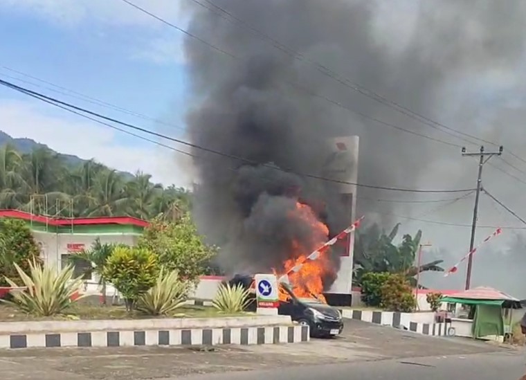 Api yang membakar sebuah mobil di depan SPBU Desa Komangaan, Kecamatan Bolaang, Minggu pagi, 14 September 2025. Insiden yang terjadi sekitar pukul 08.15 WITA ini sempat memicu kepanikan warga karena jaraknya yang dekat dengan tangki bahan bakar. Foto: Tangkapan layar salah satu postingan di media sosial facebook