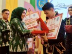 Bupati Labuhanbatu dr. Hj. Maya Hasmita, Sp.OG., MKM. menyerahkan penghargaan kepada Duta Pajak Daerah 2025 dalam Grand Final Pemilihan Duta Generasi Peduli Pajak Daerah di Ballroom Suzuya Hotel Rantauprapat, Jumat, 24 Oktober 2025. Foto: Heri/ikn