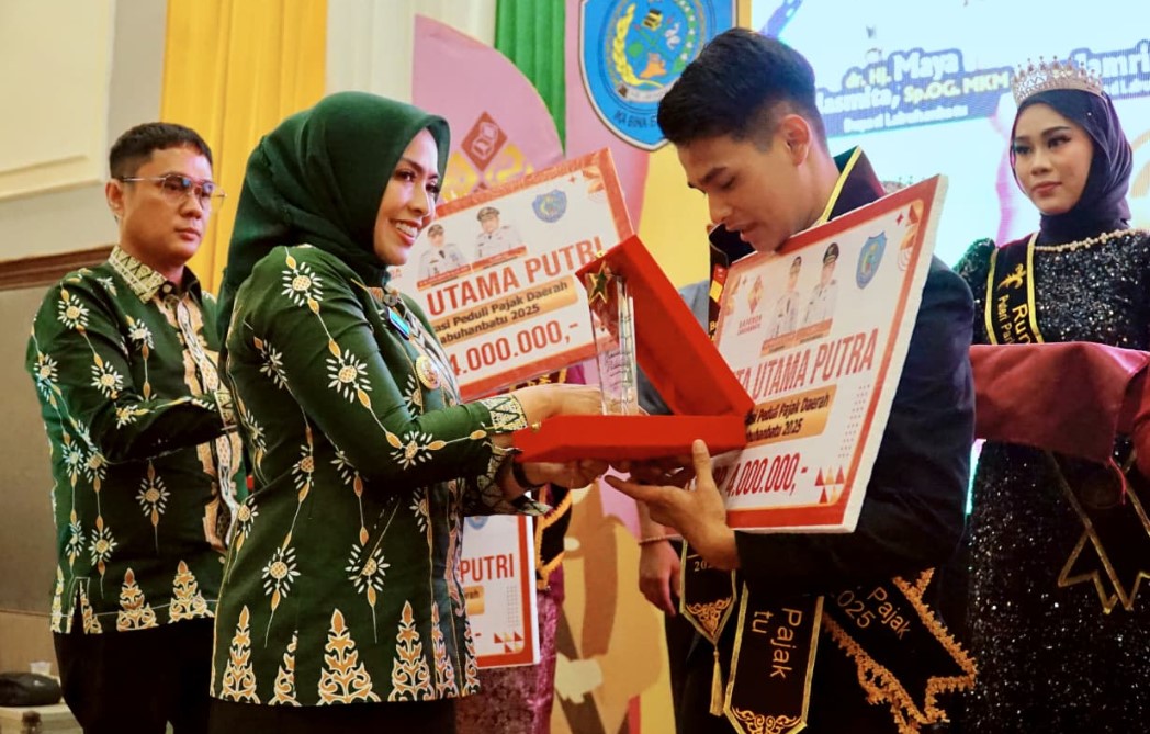 Bupati Labuhanbatu dr. Hj. Maya Hasmita, Sp.OG., MKM. menyerahkan penghargaan kepada Duta Pajak Daerah 2025 dalam Grand Final Pemilihan Duta Generasi Peduli Pajak Daerah di Ballroom Suzuya Hotel Rantauprapat, Jumat, 24 Oktober 2025. Foto: Heri/ikn