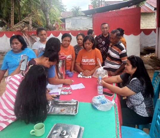 Warga Pulau Bangka antre membeli bahan pokok dalam kegiatan Pasar Murah Bersubsidi yang digelar Dinas Perdagangan Kabupaten Minahasa Utara di Kantor Desa Kahuku, Kamis (30 Oktober 2025). Foto: Den/ikn