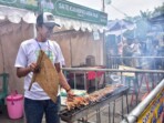Kepulan asap dari panggangan sate memenuhi udara di depan deretan stand pada Festival Sate Tegal 2025 di Jalan dr. Soetomo, Alun-Alun Hanggawana, Slawi, Kamis, 13 November 2025. Foto: Agung/TN